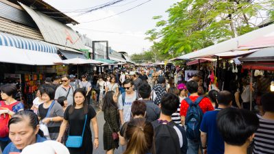 Tourists and locals in a crowded main walkway at Chatuchak Market