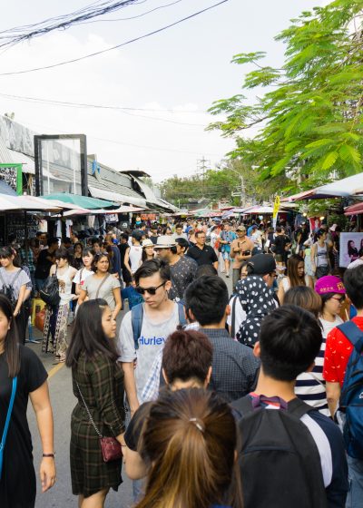 Tourists and locals in a crowded main walkway at Chatuchak Market