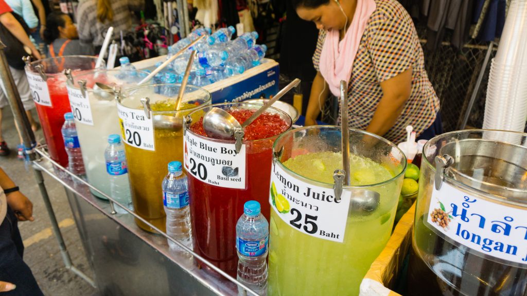 Fresh juice drink vendor selling cups of juice and tea.